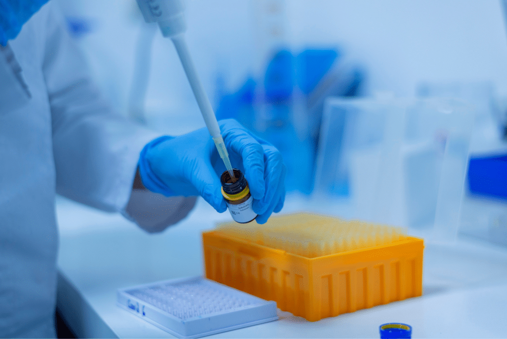 vědec v laboratoři plní lahvičku oranžový boxu na vzorky na stole