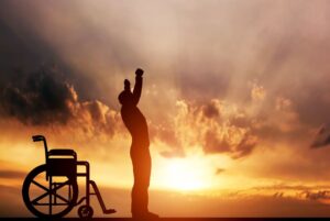 muž stojící před invalidním vozíkem a nebe