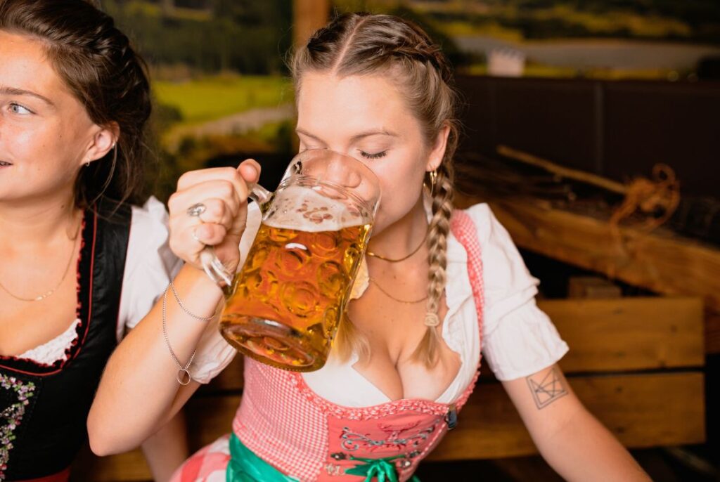 dívka s copánky popíjí pivo z tupláku