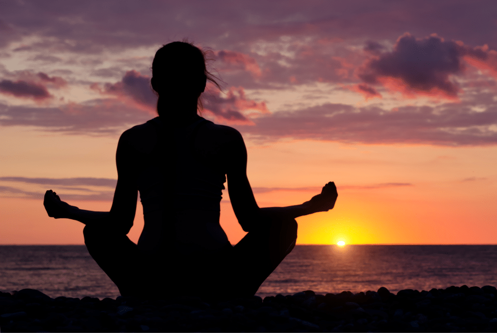 žena u západu slunce při meditaci