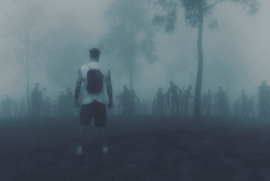 muž stojící před lesem v mlze